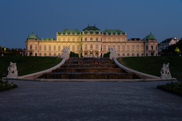 Obraz premium Famous Belvedere castle (Schloss Belvedere) surrounded by gardens with fountains and classic statues at night, Vienna, Austria