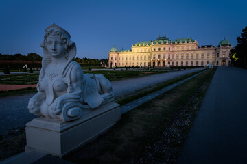 Famous Belvedere castle (Schloss Belvedere) surrounded by gardens with classic statues at night, Vienna, Austria