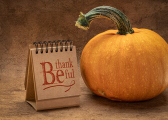 Be thankful - inspirational  handwriting in a spiral sketchbook or calendar with a pumpkin, Thanksgiving concept
