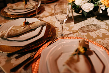 wedding decoration - table set with plates, cutlery and glasses