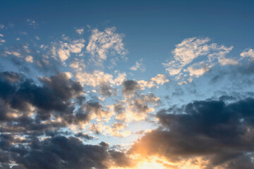 blue sky with clouds beautifully illuminated by the setting sun as a natural background