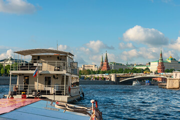Obraz premium view from a tourist ship on the Moskva River and the towers of the Moscow Kremlin against the background of a blue cloudy sky