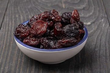 dried sultana raisins in a bowl on a wooden background