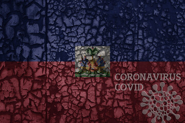 flag of haiti on a old metal rusty cracked wall with text coronavirus, covid, and virus picture.