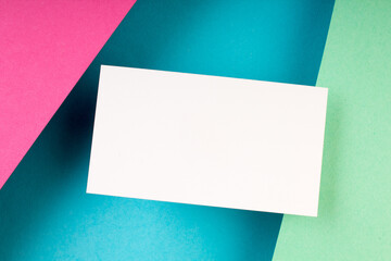 Business card blank over colorful background. Copy space for text. Top view.Business card blank over colorful abstract background. Corporate stationery branding mock-up. Copy space for text. Top view.