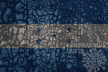 flag of honduras on a old metal rusty cracked wall with text coronavirus, covid, and virus picture.