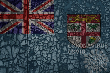 flag of Fiji on a old metal rusty cracked wall with text coronavirus, covid, and virus picture.