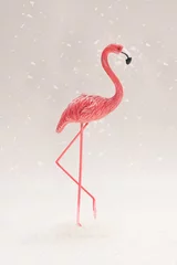 Foto op Plexiglas anti-reflex Snowing minimal concept. A pink toy flamingo standing alone while snowflakes falls around, light gray © DPA