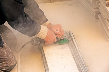A man polishes a granite slab with a grinder. Work on stone with an angle grinder.