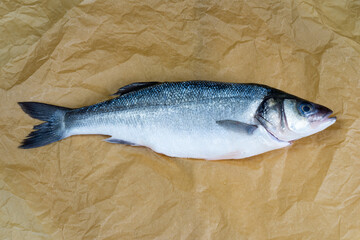 Fresh Sea bass on brown paper background, fresh and healthy food from the fish market
