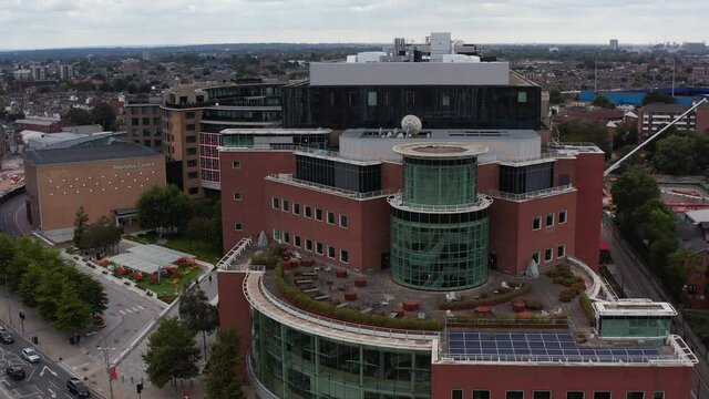 Ascending footage of Television centre building. Geometric shapes modern design building with large terrace. London, UK