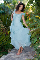 attractive brunette woman in a tropical environment walking among the flowers