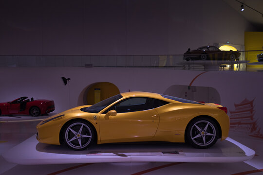 Modena, Italy - July 14, 2021: Yellow racing Ferrari 458 model high-performance Italian sports car in a dark hangar in Museo Casa Enzo Ferrari, Italy.