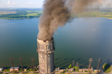 Aerial view of coal power plant high pipes with black smokestack polluting atmosphere. Electricity production with fossil fuel concept © bilanol