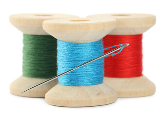 Different colorful sewing threads with needle on white background, closeup