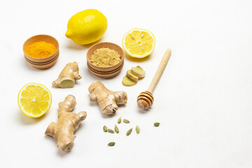 Fototapeta na wymiar Ginger root, honey stick and Cardamom and dry ginger, lemon on table.