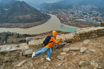 Young girl tourist rejoices posing against the backdrop of an amazing natural landscape. The...