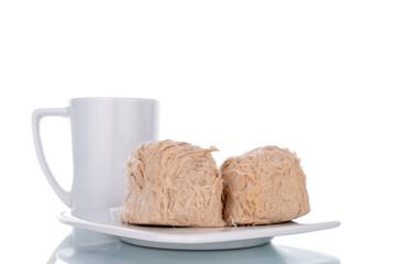 Two sweet cotton candy on a saucer with a cup, close-up, isolated on white.