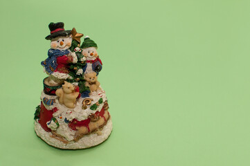 Christmas composition with snowmen, a bear and a squirrel on a green background