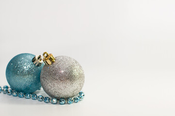 white and blue shiny balls and a blue garland on a white background
