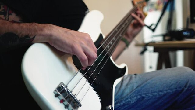 Bassist playing electric guitar at home