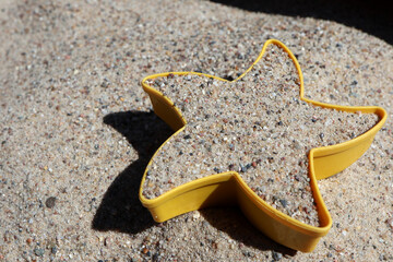 sandbox form in sand at the beach in sunny summer vacation