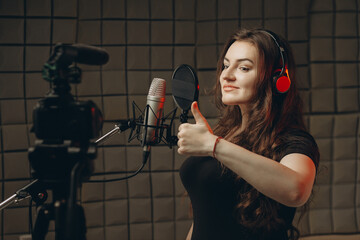 Attractive woman blogger speaks about professional voice over and dubbing, she recording video...