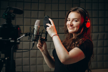 Attractive woman blogger speaks about professional voice over and dubbing, she recording video...