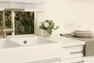 White sink with tap near window in kitchen. Interior design