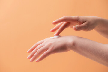 Young female hands applying cream or lotion