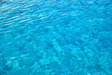 Obraz premium Closeup surface of blue clear water with small ripple waves in swimming pool.
