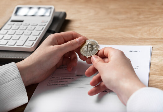 Bitcoin coin and paper invoice document. Payments with crypto currency in business transactions concept.