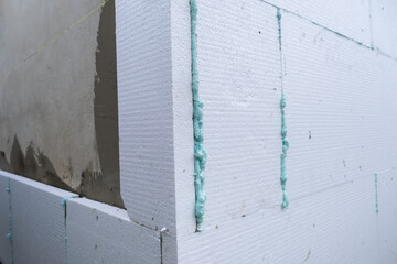 Installation of styrofoam insulation sheets on house facade wall for thermal protection.