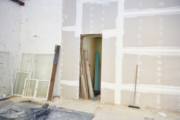 Renovation site with blank wall and window frames.