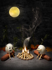 two eggs tell scary stories around the campfire at night