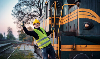Safety first. Technician controls correctness of the locomotive and showing thumb up. Transportation concept