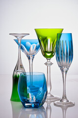 photographic arrangement of a set of different crystal glasses of different shapes, colors and uses