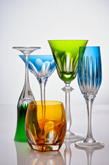 photographic arrangement of a set of different crystal glasses of different shapes, colors and uses