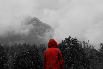 Obraz premium Person standing in front of foggy mountains one colored black and white