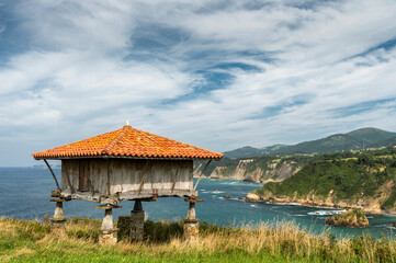 Old horreo, ancestral construction typical of the region of Asturias, in the north of Spain, with the Atlantic Ocean in the background.
