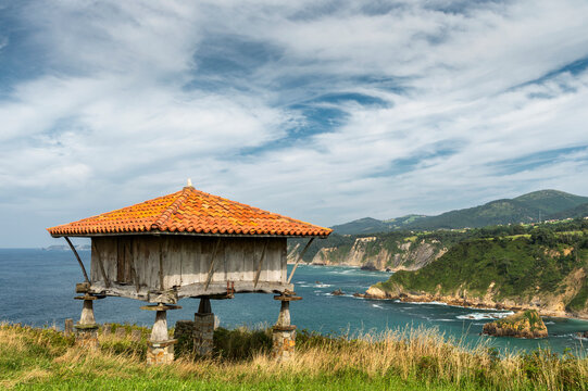 Old horreo, ancestral construction typical of the region of Asturias, in the north of Spain, with the Atlantic Ocean in the background.