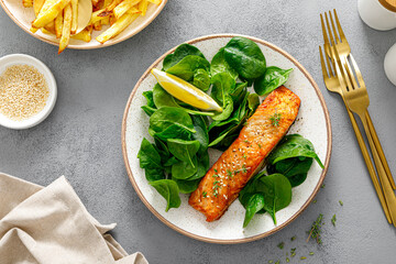 Grillet salmon and fresh spinach salad dressed with lemon