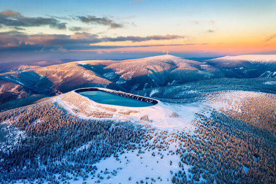 Pumped storage hydro plant "Dlouhe strane" in Jeseniky mountains during sunset. Aerial view on evening winter mountains. Third biggest pumped storage hydro plant in the world
