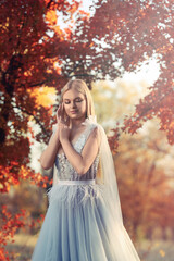 Beautiful girl wearing fairy dress in autumn forest