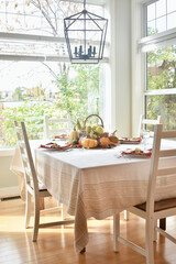 Fall harvest table centerpiece of pumpkins, squash and apples for Thanksgiving table setting 