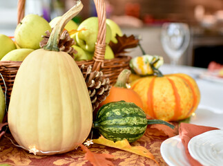 Fall harvest table centerpiece of pumpkins, squash and apples for Thanksgiving table setting 