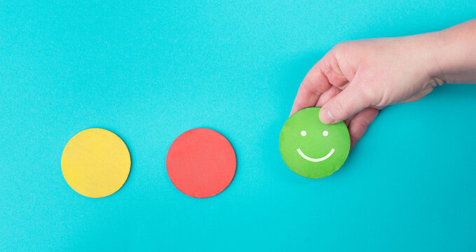 Hand Holds A Green Smiling Face, Red And Yellow Circle Empty, Blue Colored Background, Copy Space, Customer Review