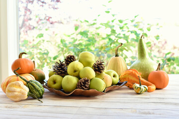 Fall harvest table centerpiece of pumpkins, squash and apples for Thanksgiving table setting 