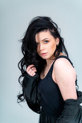 Portrait of beautiful lady in jacket looking at the camera while posing. Fashionable lifestyle woman in dark jacket