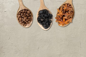 Spoons with different legumes on desk background